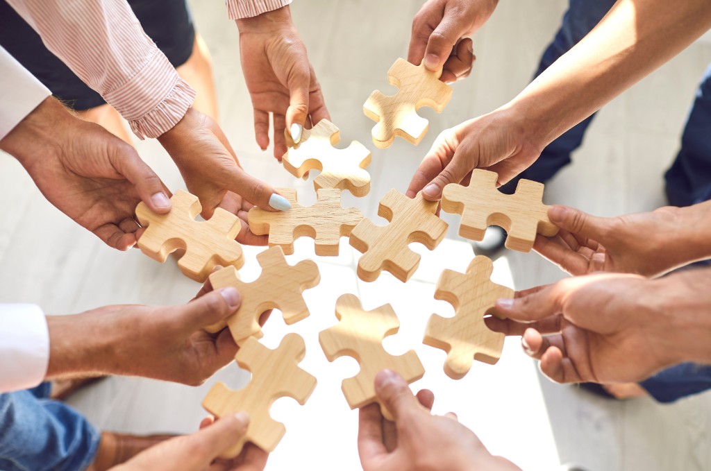 Equipe encaixando peças de um quebra-cabeça